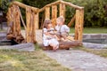 A little girl and a boy sit on a bridge across the river. Royalty Free Stock Photo