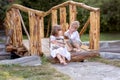 A little girl and a boy sit on a bridge across the river. A girl holds a pet rabbit in her hands. Royalty Free Stock Photo