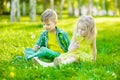 Little girl and boy sitting together on green grass Royalty Free Stock Photo