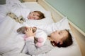 Little girl and boy sleeping in bed with soft