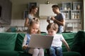 Little girl and boy using laptop while parents talking Royalty Free Stock Photo