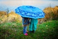 Little girl and boy with umbrella playing in the rain. Kids play outdoor by rainy weather in fall. Autumn fun for children. Toddle Royalty Free Stock Photo