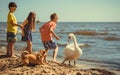 Little girl boys kids on beach have fun with swan.