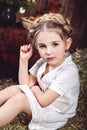 Little girl with braids on hay