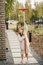 A little girl with a brush cleans a path on the street in the courtyard Royalty Free Stock Photo