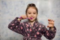 Little girl brushes her teeth with toothpaste with an hourglass timer Royalty Free Stock Photo