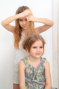 Little girl brushing hair of her younger sister