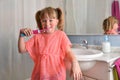 Little girl brushing her teeth with electric toothbrush in bathroom Royalty Free Stock Photo