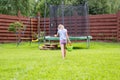 Little girl with bucket of water going to wash her trampoline Royalty Free Stock Photo