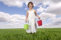 Little girl with buckets in meadow