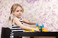 Little girl builds bricks at table Royalty Free Stock Photo