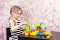 Little girl builds bricks at table Royalty Free Stock Photo