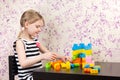 Little girl builds bricks at table Royalty Free Stock Photo