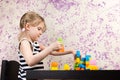 Little girl builds bricks at table Royalty Free Stock Photo