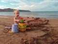 Little girl builds a sand castle