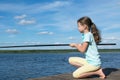 Little girl came to fish on the lake on a sunny day