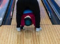 A mother helps her little daughter throw the heavy bowling ball