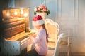 Little girl in the cap of Santa Claus is waiting for the New Year. The girl on Christmas is playing the piano. Royalty Free Stock Photo