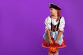 Little girl in a carnival costume of a pirate for Halloween on a purple background. Royalty Free Stock Photo