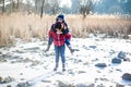 Little girl carries her brother on the shoulder in the winter outdoors in the park