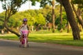 Little girl carrying his little sibling sister on baby bike seat on the park