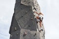 Little girl in casual white clothes training rock climbing outdoors Royalty Free Stock Photo
