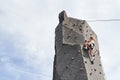 Little girl in casual white clothes training rock climbing outdoors Royalty Free Stock Photo