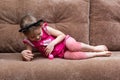 Little girl with cat face painting play ball on couch Royalty Free Stock Photo