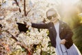Little girl with a cat hat and black sunglasses in spring near blooming tree Royalty Free Stock Photo