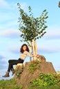 Little girl  with cat sitting on stump by new linden Royalty Free Stock Photo