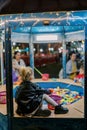 Little girl catches fish with a toy fishing rod while sitting by a toy pool at a fair with children. Back view Royalty Free Stock Photo