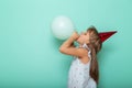 Little girl celebrating birthday and blowing a balloon Royalty Free Stock Photo