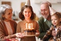 Little girl celebrating birthday while her loving senior grandparents at home Royalty Free Stock Photo