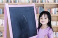 Little girl with chalkboard in library Royalty Free Stock Photo