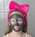 Little girl with charcoal mask on her face. Skin hygiene Royalty Free Stock Photo