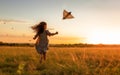 Little girl chasing after paper airplane in the field