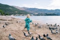 Little girl chasing pigeons along the seashore