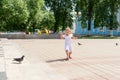 Little girl chasing pigeons in summer park Royalty Free Stock Photo