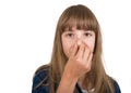 Little girl in checked brown shirt pinching her nose because of bad smell. She is unhappy with stench and looking at Royalty Free Stock Photo