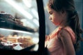 Little Girl Checking Desserts in a Showcase Window of a Confectionery Shop Royalty Free Stock Photo