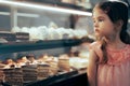 Little Girl Checking Desserts in a Showcase Window of a Confectionery Shop Royalty Free Stock Photo