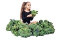Little girl cheerfully holds head of broccoli and licks her lips