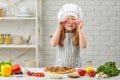 Little girl in chef hat and an apron cooking pizza Royalty Free Stock Photo