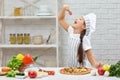 Little girl in chef hat and an apron cooking pizza Royalty Free Stock Photo