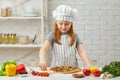 Little girl in chef hat and an apron cooking pizza Royalty Free Stock Photo