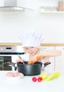 Little girl in chef hat cooking. Royalty Free Stock Photo