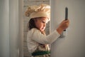 Little girl in a chef hat looks into the refrigerator Royalty Free Stock Photo