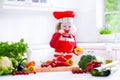 Little girl in chef hat preparing lunch Royalty Free Stock Photo