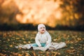 A little girl child in the autumn park smiles, spends time. Beautiful autumn background. Royalty Free Stock Photo