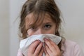 Little girl child blows snot out of nose into paper handkerchief during a cold Royalty Free Stock Photo